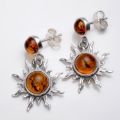 Close-up of genuine Baltic honey amber “Sun” earrings in 925 sterling silver, two-tone amber stud and dangling sunburst charm with post back closures on a white background.