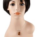 Model wearing Lois oval Baltic honey amber pendant necklace in 925 sterling silver on 18 inch chain, showcasing genuine amber cabochon with natural inclusions