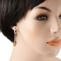 Model wearing sterling silver Baltic honey amber drop earrings with English lock closure, handmade Polish jewelry featuring round genuine amber cabochon