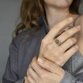 Sterling silver Celtic knot ring with green Baltic amber shown worn on a model’s hand