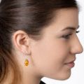 Model wearing genuine Baltic honey amber teardrop drop earrings in 925 sterling silver, lightweight natural amber jewelry shown on woman for everyday elegant style