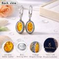 Back view of oval Baltic amber drop earrings in 925 sterling silver vintage filigree setting, shown on a soft white background with feature icons and Holiday Gift Shops velvet gift pouch included.
