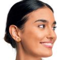 Woman wearing rectangular Baltic amber and sterling silver stud earrings, shown in side profile against a white background.