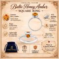 A vintage-style product infographic for a sterling silver Baltic honey amber square ring on a parchment-colored background with ornate decorative corners. The layout features two views of the ring in the center, surrounded by callouts describing genuine Baltic amber, 925 sterling silver, handcrafted quality, lightweight comfort, and a warm golden hue. It also lists the stone size as approximately 0.3" x 0.3" (7.5 x 7.5 mm), shows a blue Holiday Gift Shops gift pouch, mentions a certificate of authenticity, and notes the ring is made in Gdansk, Poland.