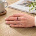 Sterling silver Baltic amber ring shown on a hand, featuring a slim rectangular cognac amber stone and Greek key detailing.