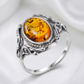 Sterling silver ring with oval Baltic honey amber stone in an ornate vintage-style setting