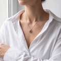 Woman wearing genuine Baltic honey amber pendant necklace in 925 sterling silver, Beaming Sun handmade Polish amber jewelry on 18 inch chain