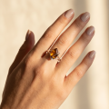 Hanna Baltic Honey Amber Adjustable Ring in Sterling Silver worn on a woman's finger, showcasing a genuine honey amber stone in a modern sterling silver setting.