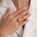 Brigitte Multicolor Baltic Amber Ring in Sterling Silver worn on a woman's finger, showcasing a flower-inspired design with genuine multicolor Baltic amber stones.