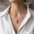 Woman wearing the Mackenzie Baltic Amber Pendant in Sterling Silver on a delicate silver chain, styled with a white shirt in a luxury jewelry lifestyle portrait.
