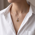Woman wearing the Baltic Amber Sun Pendant in Sterling Silver on a delicate silver chain, showcasing genuine Baltic amber in an elegant luxury jewelry lifestyle setting.