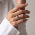 Woman wearing the Baltic Green Amber Celtic Knot Ring in Sterling Silver, showcasing a genuine green Baltic amber gemstone and elegant Celtic knot detailing in a luxury jewelry lifestyle setting.