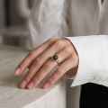 Woman wearing the Clara Baltic Green Amber Ring in Sterling Silver, showcasing a genuine green Baltic amber gemstone and polished 925 sterling silver in an elegant luxury jewelry lifestyle setting.