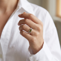 Woman wearing the Baltic Green Amber Ring in Sterling Silver, showcasing a genuine green Baltic amber gemstone and polished 925 sterling silver in an elegant luxury jewelry lifestyle setting.