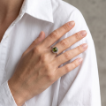 Woman wearing the Megan Baltic Green Amber Ring in Sterling Silver, showcasing a genuine green Baltic amber gemstone and polished 925 sterling silver in an elegant luxury jewelry lifestyle setting.