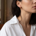Woman wearing the Lena Baltic Honey Amber Earrings in Sterling Silver, showcasing genuine honey Baltic amber and polished 925 sterling silver in an elegant luxury jewelry lifestyle setting.