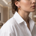 Woman wearing the Liliana Baltic Honey Amber Earrings in Sterling Silver, showcasing genuine honey Baltic amber and polished 925 sterling silver in an elegant luxury jewelry lifestyle setting.
