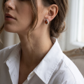 Woman wearing the Marcelina Baltic Honey Amber Earrings in Sterling Silver, showcasing genuine honey Baltic amber and polished 925 sterling silver in an elegant luxury jewelry lifestyle setting.