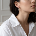 Woman wearing the Maryl Baltic Honey Amber Earrings in Sterling Silver, showcasing genuine honey Baltic amber and polished 925 sterling silver in an elegant luxury jewelry lifestyle setting.