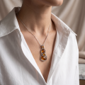 Woman wearing the Taylor Baltic Honey Amber Pendant in Sterling Silver on a delicate silver chain, showcasing genuine honey Baltic amber in an elegant luxury jewelry lifestyle setting.
