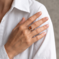 Woman wearing the Cora Baltic Honey Amber Ring in Sterling Silver, showcasing a genuine honey Baltic amber gemstone and polished 925 sterling silver in an elegant luxury jewelry lifestyle setting.
