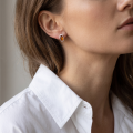 Woman wearing the Madelyn Baltic Amber Earrings in Sterling Silver, showcasing genuine Baltic amber and polished 925 sterling silver in an elegant luxury jewelry lifestyle setting.