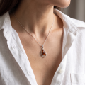 Woman wearing the Ava Baltic Amber Pendant in Sterling Silver on a delicate silver chain, showcasing genuine Baltic amber and polished 925 sterling silver in an elegant luxury jewelry lifestyle setting.