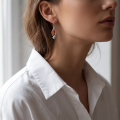 Woman wearing the Johanna Baltic Honey Amber Earrings in Sterling Silver, showcasing genuine honey Baltic amber and polished 925 sterling silver in an elegant luxury jewelry lifestyle setting.
