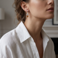 Woman wearing the Theresa Baltic Honey Amber Earrings in Sterling Silver, showcasing genuine honey Baltic amber and polished 925 sterling silver in an elegant luxury jewelry lifestyle setting.