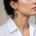Woman wearing the Agnes Baltic Honey Amber Earrings in Sterling Silver, showcasing genuine honey Baltic amber and polished 925 sterling silver in an elegant luxury jewelry lifestyle setting.