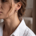 Woman wearing the Multicolor Baltic Amber Hoop Huggie Hoop Earrings in Sterling Silver, showcasing genuine multicolor Baltic amber and polished 925 sterling silver in an elegant luxury jewelry lifestyle setting.