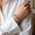 Woman wearing the Baltic Honey Amber Bracelet in Sterling Silver, showcasing genuine honey Baltic amber and polished 925 sterling silver in an elegant luxury jewelry lifestyle setting.