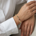 Woman wearing the Baltic Amber Bracelet in Sterling Silver, showcasing genuine Baltic amber and polished 925 sterling silver in an elegant luxury jewelry lifestyle setting.