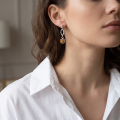 Woman wearing the Grace Baltic Honey Amber Earrings in Sterling Silver, showcasing genuine honey Baltic amber and polished 925 sterling silver in an elegant luxury jewelry lifestyle setting.