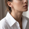 Woman wearing the Aleta Baltic Honey Amber Earrings in Sterling Silver, showcasing genuine honey Baltic amber and polished 925 sterling silver in an elegant luxury jewelry lifestyle setting.