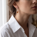 Woman wearing the Jennifer Baltic Honey Amber Earrings in Sterling Silver, showcasing genuine honey Baltic amber and polished 925 sterling silver in an elegant luxury jewelry lifestyle setting.