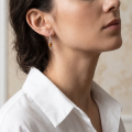 Woman wearing the Milena Baltic Honey Amber Earrings in Sterling Silver, showcasing genuine honey Baltic amber and polished 925 sterling silver in an elegant luxury jewelry lifestyle setting.