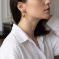 Woman wearing the Shannon Baltic Honey Amber Earrings in Sterling Silver, showcasing genuine honey Baltic amber and polished 925 sterling silver in an elegant luxury jewelry lifestyle setting.