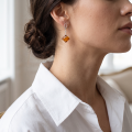 Woman wearing the Simone Baltic Honey Amber Earrings in Sterling Silver, showcasing genuine honey Baltic amber and polished 925 sterling silver in an elegant luxury jewelry lifestyle setting.