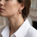 Woman wearing the Simone Baltic Honey Amber Earrings in Sterling Silver, showcasing genuine honey Baltic amber and polished 925 sterling silver in an elegant luxury jewelry lifestyle setting.