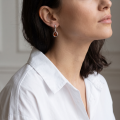 Woman wearing the Shawn Baltic Honey Amber Earrings in Sterling Silver, showcasing genuine honey Baltic amber and polished 925 sterling silver in an elegant luxury jewelry lifestyle setting.