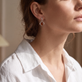 Woman wearing the Katie Baltic Honey Amber Earrings in Sterling Silver, showcasing genuine honey Baltic amber and polished 925 sterling silver in an elegant luxury jewelry lifestyle setting.
