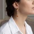 Woman wearing the Victoria Multicolor Baltic Amber Earrings in Sterling Silver, showcasing genuine multicolor Baltic amber and polished 925 sterling silver in an elegant luxury jewelry lifestyle setting.