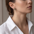 Woman wearing the Phoebe Baltic Green Amber Earrings in Sterling Silver, showcasing genuine green Baltic amber and polished 925 sterling silver in an elegant luxury jewelry lifestyle setting.