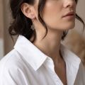 Woman wearing the Baltic Honey Amber Spiderweb Earrings in Sterling Silver, showcasing genuine honey Baltic amber and polished 925 sterling silver in an elegant luxury jewelry lifestyle setting.