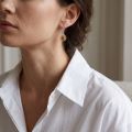 Woman wearing the Baltic Honey Amber Drop Earrings in Sterling Silver, showcasing genuine honey Baltic amber and polished 925 sterling silver in an elegant luxury jewelry lifestyle setting.