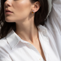 Woman wearing the Leah Baltic Honey Amber Earrings in Sterling Silver, showcasing genuine honey Baltic amber and polished 925 sterling silver in an elegant luxury jewelry lifestyle setting.