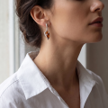 Woman wearing the Stella Baltic Honey Amber Earrings in Sterling Silver, showcasing genuine honey Baltic amber and polished 925 sterling silver in an elegant luxury jewelry lifestyle setting.