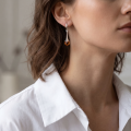 Woman wearing the Kylie Baltic Honey Amber Earrings in Sterling Silver, showcasing genuine honey Baltic amber and polished 925 sterling silver in an elegant luxury jewelry lifestyle setting.