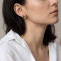 Woman wearing the Baltic Honey Amber Bow Floral Stud Earrings in Sterling Silver, showcasing genuine honey Baltic amber and polished 925 sterling silver in an elegant luxury jewelry lifestyle setting.